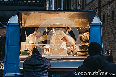 People buying food from a Sud Italia pizza stall inside Spitalfields Market, London, UK Editorial Stock Photo