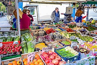 People buying fruits and vegetables at market stall in Portobello Road Market, Notting Hill, United Kingdom Editorial Stock Photo
