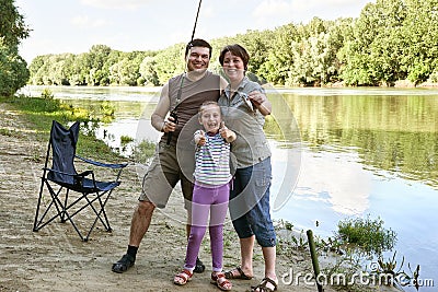 People camping and fishing, family active in nature, fish caught on bait, river and forest, summer season Stock Photo