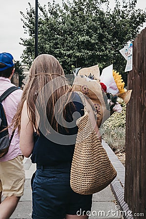 People carry plants and flowers purchased at the Columbia Road Flower Market, London, UK. Editorial Stock Photo