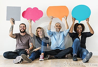 People carrying speech bubble icons sitting on floor Stock Photo