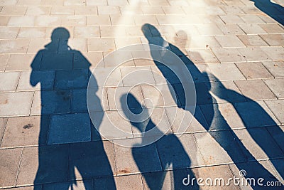 People casting shadows on the pavement Stock Photo