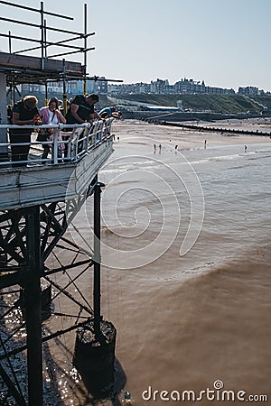 People catching crabs with buckets lowered from Cromer pier, Norfolk, UK Editorial Stock Photo