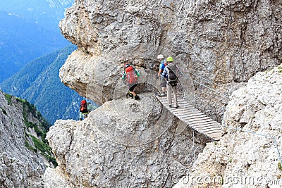 People climbing the Via Ferrata Severino Casara with bridge in Sexten Dolomites mountains, South Tyrol Editorial Stock Photo