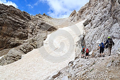 People climbing the Via Ferrata Severino Casara and snow field in Sexten Dolomites mountains, South Tyrol Editorial Stock Photo