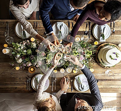 People Cling Wine Glasses on Wedding Reception with Bride and Groom Stock Photo