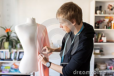 Fashion designer with dummy making dress at studio Stock Photo