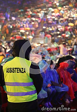 People during a concert and a boy with jacket with text ASSISTEN Stock Photo