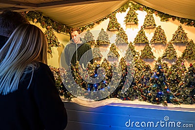 People at counter with Christmas trees in Christmas market at Cathedral Square Vilnius at night Editorial Stock Photo