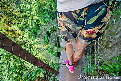 People crossing Capilano Cliff Walk Suspension Bridge in Vancouver, detail on tourists legs, downward view Stock Photo