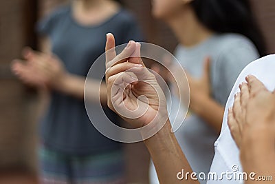 People doing percussion with their bodies. A hand in the foreground making a clicking sound Stock Photo