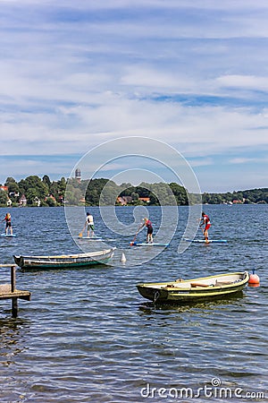 People doing standup paddleboarding in the lake of Plon Editorial Stock Photo