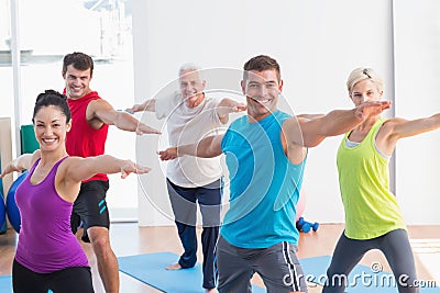 People doing warrior pose in yoga class Stock Photo