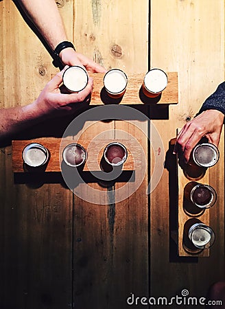 People drinking local beer from tasting palettes at craft brewery Stock Photo