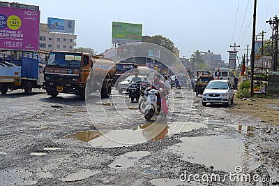 People driving on damaged road with potholes, Pune Editorial Stock Photo