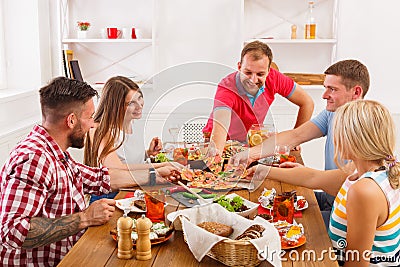 People eat pizza at festive table dinner party Stock Photo