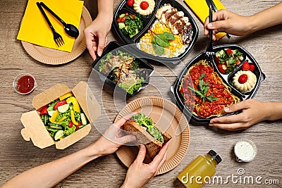 People eating healthy meals at wooden table. Food delivery Stock Photo