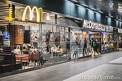 People eating at McDonalds / McCafe restaurant inside train stration Berlin Hauptbahnhof Editorial Stock Photo