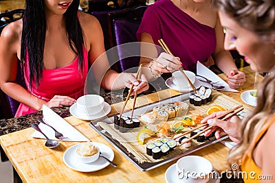 People eating sushi in Asian restaurant Stock Photo