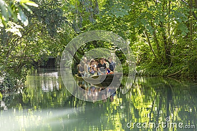 people enjoy a boat trip on a green canal in Colmar Editorial Stock Photo