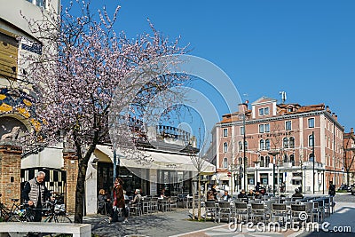 People enjoy a cafe along Santa Maria Elisabetta street, heart of the island of Lido, near to Venice Editorial Stock Photo
