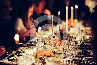 People enjoy a family dinner with candles. Big table served with food and beverages Editorial Stock Photo