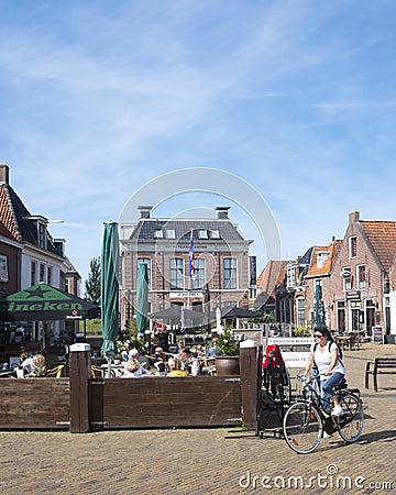 People enjoy nice weather on open air cafe in village of makkum in the netherlands Editorial Stock Photo