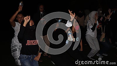People enjoying music dancing and joking together at night Editorial Stock Photo