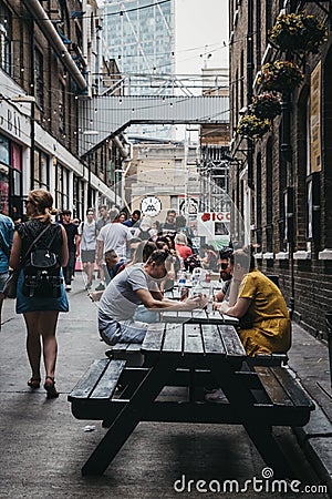 People enjoying street food in Ely`s Yard, London, UK. Editorial Stock Photo