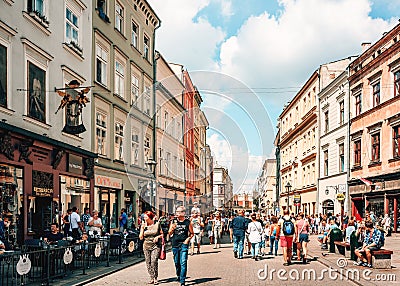 Couples and young families with children walking on busy street in old town Krakow. Editorial Stock Photo