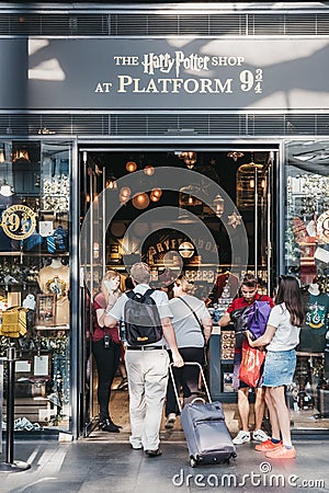 People entering Harry Potter shop by 9 3/4 platform inside King`s Cross Station, London, UK. Editorial Stock Photo