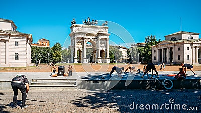 People exercise and socialise in front of Arco della Pace known as Arch of Peace in Milan, Italy, built as part of Foro Editorial Stock Photo