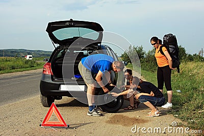 People fixing a flat tire Stock Photo