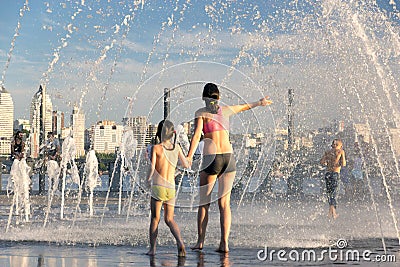 People fleeing from the heat in a city fountain in the centre of a European city Editorial Stock Photo