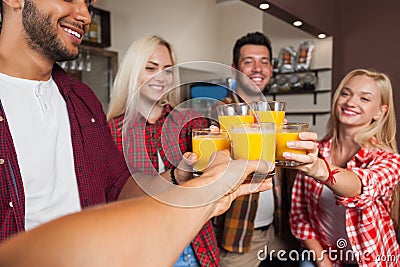 People Friends Drinking Orange Juice, Toasting At Bar Counter, Mix Race Man And Woman Cheers Stock Photo