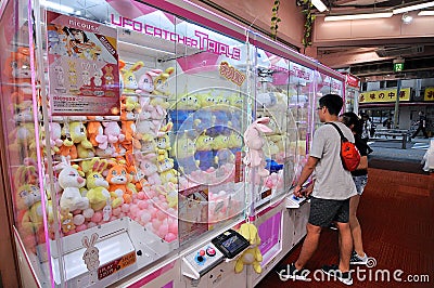 People in front of a Japanese Toy Crane Vending Machine in Tokyo Editorial Stock Photo