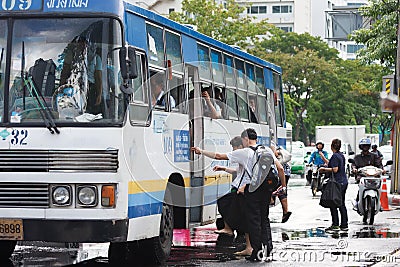 People getting on bus after the rain Editorial Stock Photo