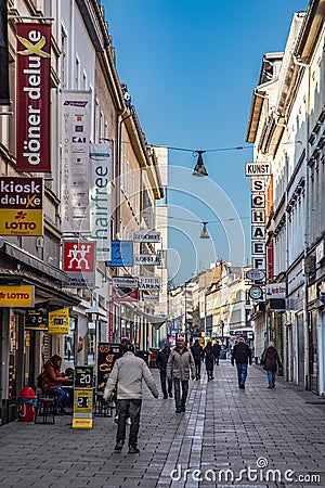 people go shopping at Faulbrunnenstrasse - engl: rotten fountain street - with historic 19th century facades downtown Wiesbaden Editorial Stock Photo