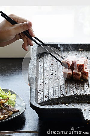 People grilling korean barbeque Stock Photo