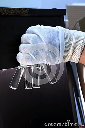 People hand holding a test tube vial sets for analysis in the gas liquid chromatograph. Laboratory assistant inserting laboratory Stock Photo