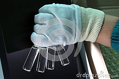 People hand holding a test tube vial sets for analysis in the gas liquid chromatograph. Laboratory assistant inserting laboratory Stock Photo