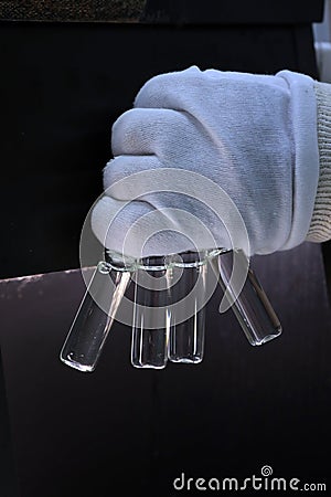 People hand holding a test tube vial sets for analysis in the gas liquid chromatograph. Laboratory assistant inserting laboratory Stock Photo