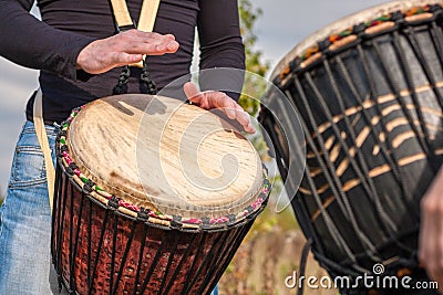 People hands playing music at djembe drums Stock Photo