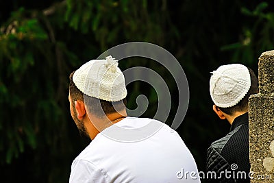 2 people, the Hasidim Jews in traditional bales sit in a park in Uman, the time of the Jewish New Year, Rosh-ha-Shana Editorial Stock Photo