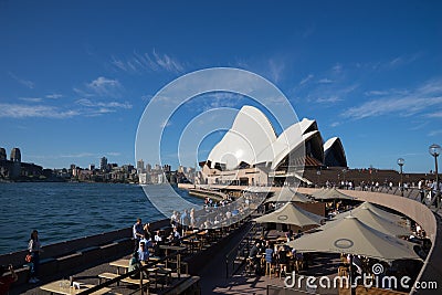 People have drink and enjoy sunny day at Opera bar in front of The Opera House, with a beautiful clear blue sky Editorial Stock Photo