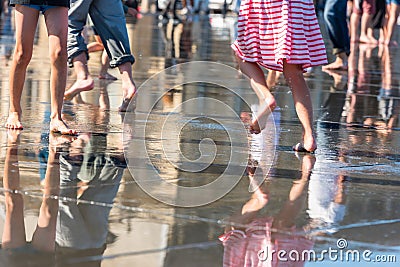 People having fun in a mirror fountain in Bordeaux, France Stock Photo