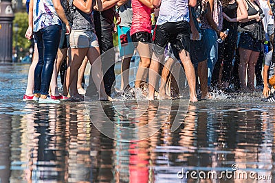 People having fun in a mirror fountain in Bordeaux, France Stock Photo