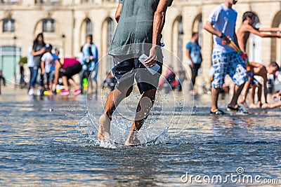 People having fun in a mirror fountain in Bordeaux, France Stock Photo