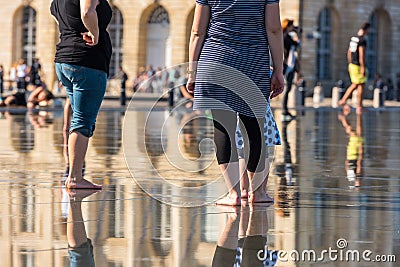 People having fun in a mirror fountain in Bordeaux, France Stock Photo