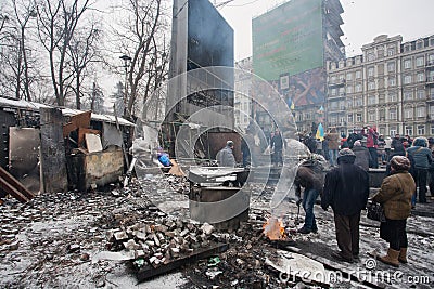 People heating by the fire near the barricades after fights with police on the broken street of Kiev during anti-government riot Editorial Stock Photo